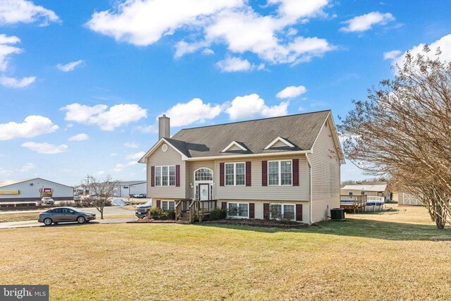 raised ranch featuring cooling unit and a front yard