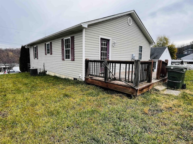 rear view of house with a lawn, central air condition unit, and a deck