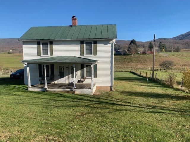 exterior space with a mountain view, a front yard, a rural view, and a patio area