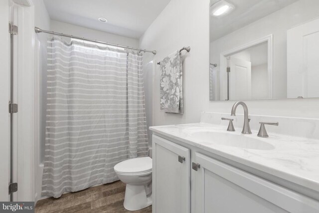 full bathroom featuring shower / tub combo with curtain, vanity, toilet, and wood-type flooring