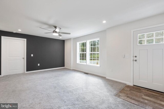 carpeted foyer entrance featuring ceiling fan