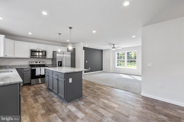 kitchen featuring gray cabinets, white cabinetry, stainless steel appliances, a center island, and decorative light fixtures