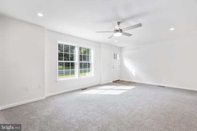 spare room with light colored carpet and ceiling fan