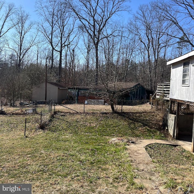 view of yard featuring an outdoor structure and fence