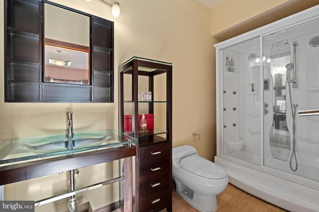 bathroom featuring walk in shower, toilet, and sink