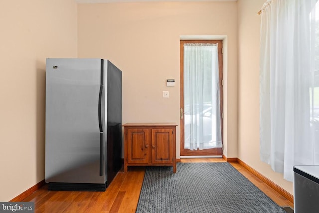 kitchen with stainless steel fridge and light hardwood / wood-style flooring