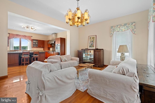 living room featuring a chandelier and light hardwood / wood-style flooring