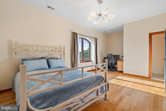 bedroom featuring light hardwood / wood-style flooring and a notable chandelier