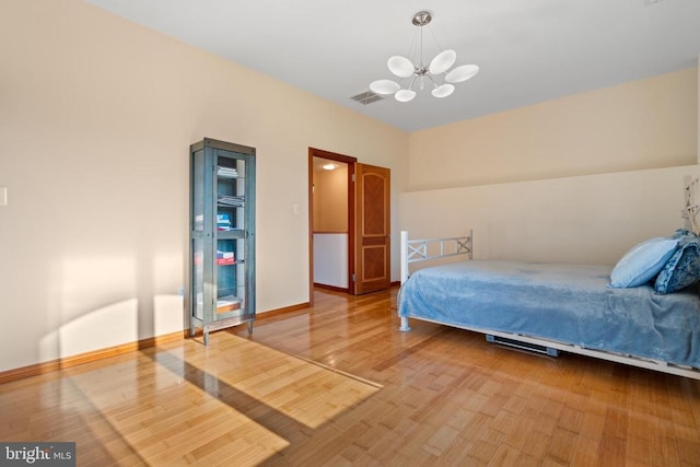 bedroom featuring hardwood / wood-style floors and a chandelier