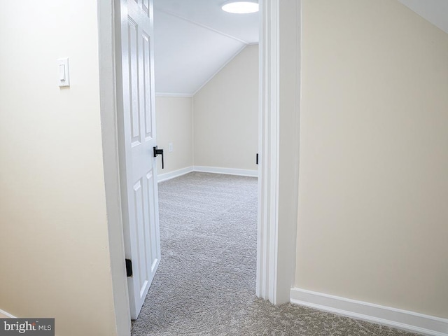 hall featuring vaulted ceiling and carpet flooring