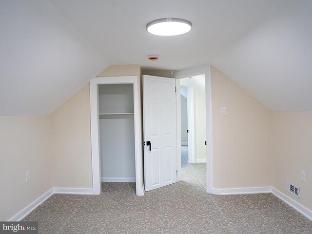 additional living space with light carpet and vaulted ceiling