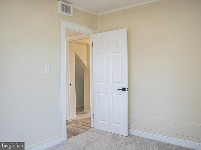 carpeted spare room featuring ornamental molding