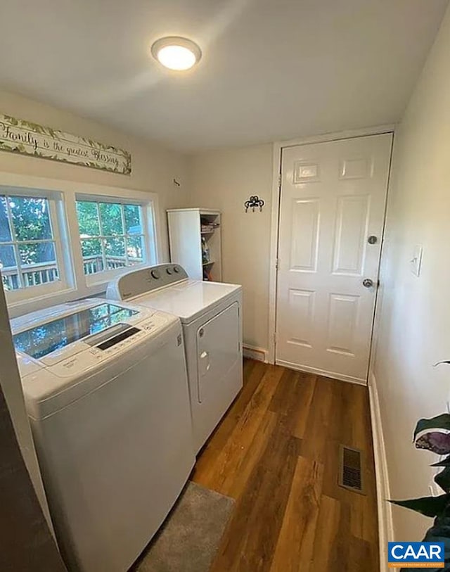 laundry area featuring dark wood finished floors, visible vents, laundry area, independent washer and dryer, and baseboards