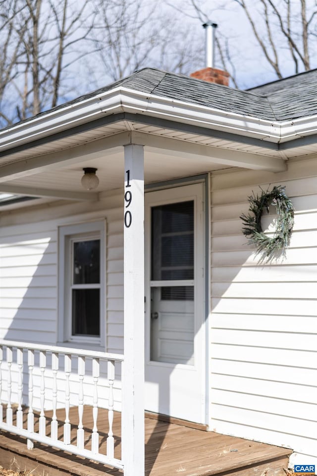 doorway to property with a shingled roof