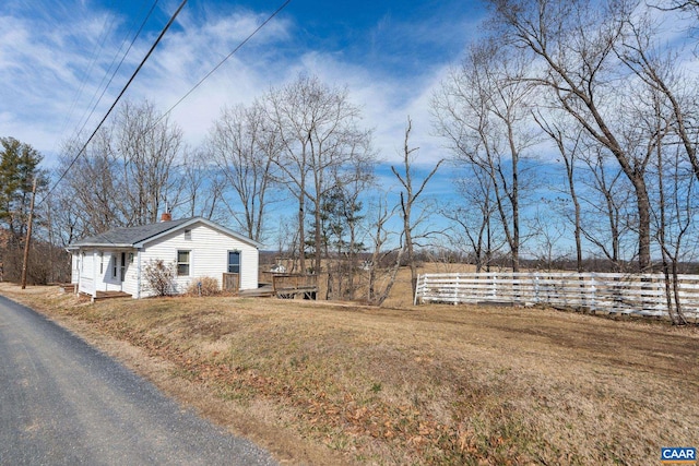 view of side of property featuring a yard and a chimney