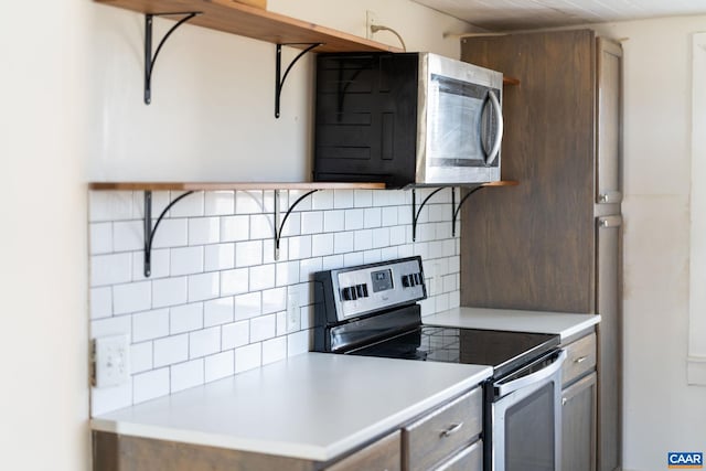 kitchen featuring appliances with stainless steel finishes, light countertops, decorative backsplash, and open shelves