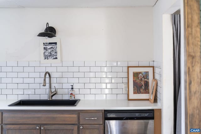 kitchen with a sink, tasteful backsplash, light countertops, and dishwasher