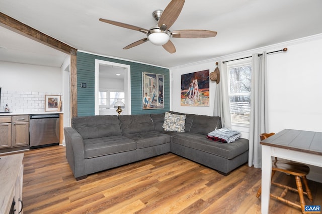 living room featuring light wood-type flooring, plenty of natural light, and crown molding