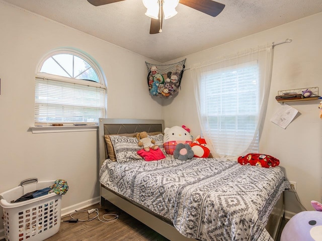 bedroom featuring hardwood / wood-style flooring, ceiling fan, and a textured ceiling