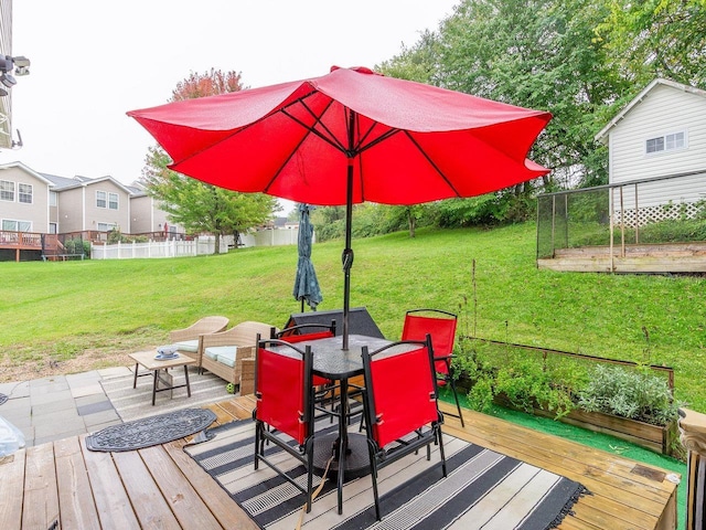 wooden deck featuring a lawn