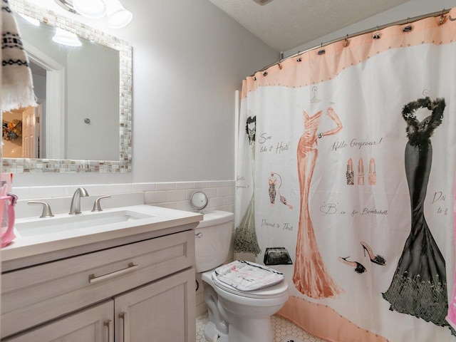 bathroom featuring tile walls, vanity, a textured ceiling, a shower with curtain, and toilet