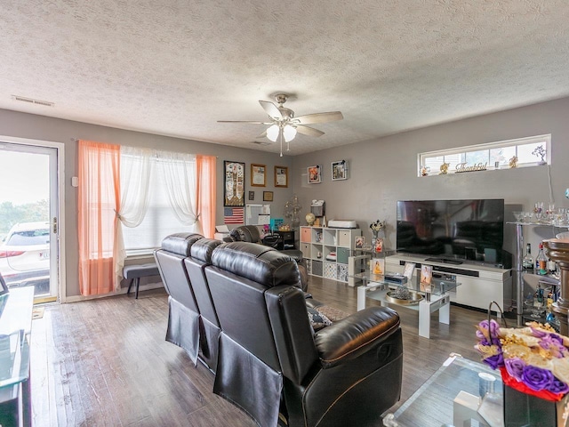 living room with hardwood / wood-style flooring, a textured ceiling, and ceiling fan