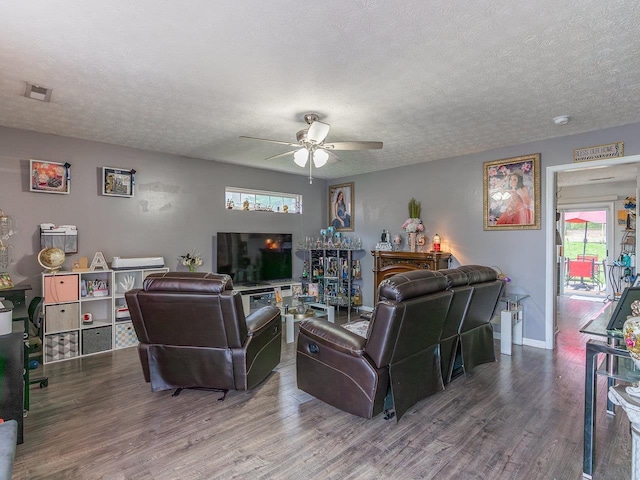 living room with ceiling fan, hardwood / wood-style floors, and a textured ceiling