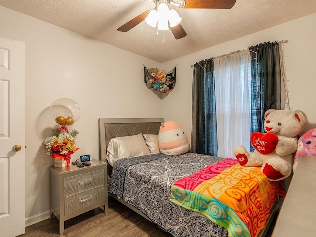 bedroom with ceiling fan, hardwood / wood-style floors, and a textured ceiling