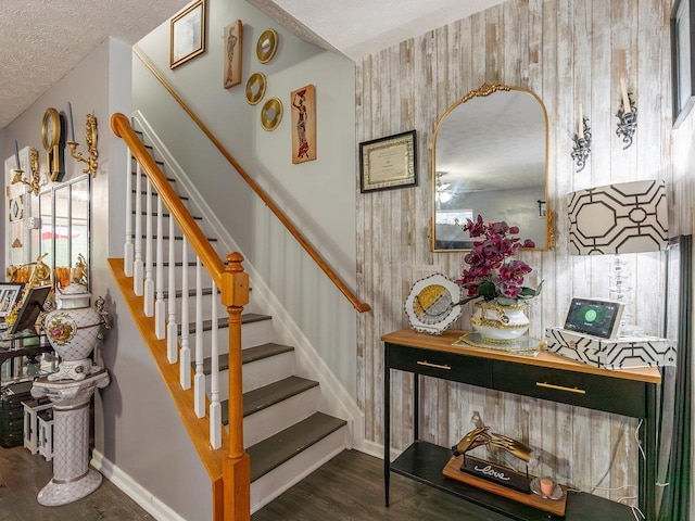 staircase featuring hardwood / wood-style floors and a textured ceiling