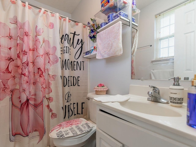 bathroom featuring vanity, curtained shower, and toilet