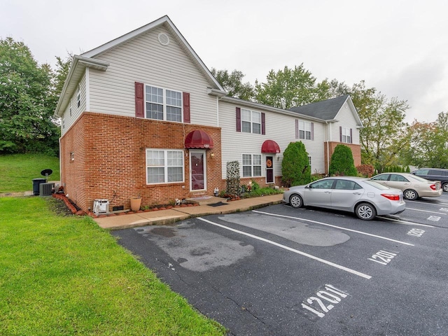 view of front of property with cooling unit and a front yard