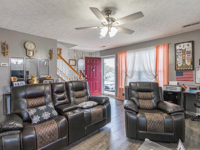 living room with ceiling fan, hardwood / wood-style floors, and a textured ceiling