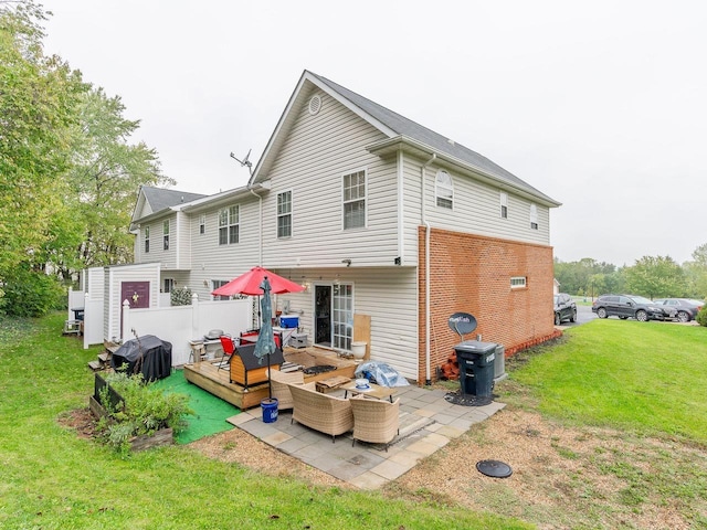 rear view of property featuring an outdoor living space, a patio, a deck, and a lawn