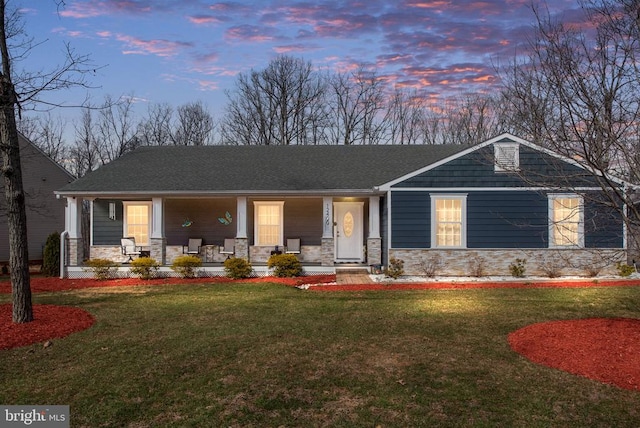 view of front facade featuring stone siding, a porch, and a front yard