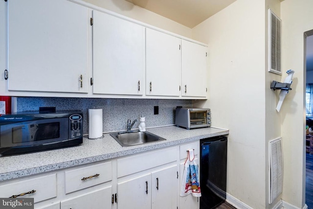 kitchen featuring visible vents, a toaster, a sink, black appliances, and light countertops