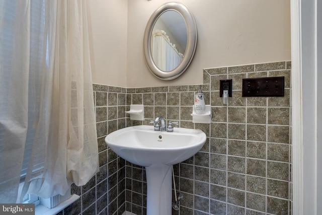 bathroom with a wainscoted wall and tile walls