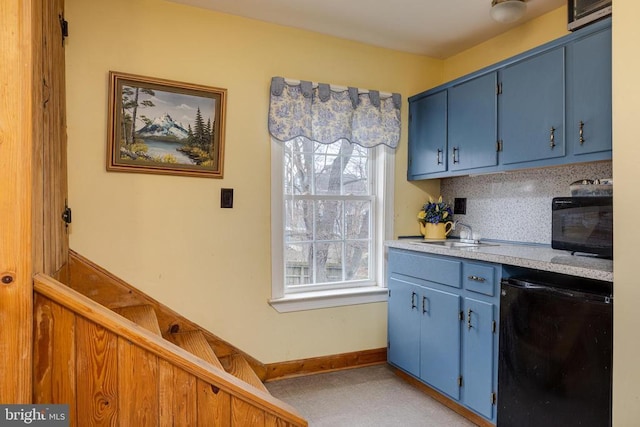 kitchen featuring blue cabinetry, plenty of natural light, refrigerator, and a sink