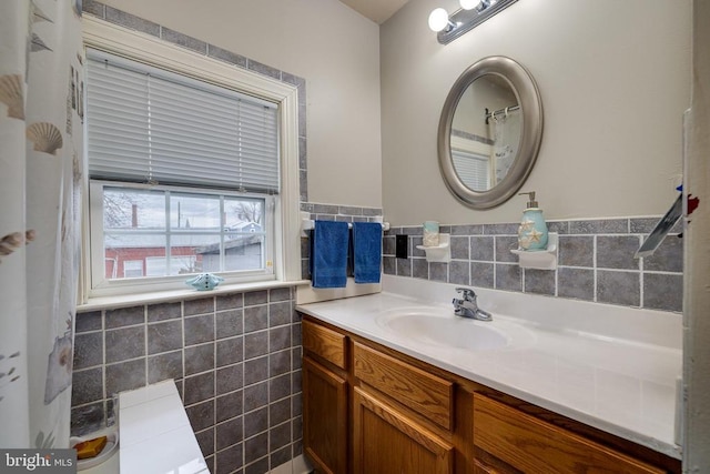 bathroom featuring vanity and tile walls