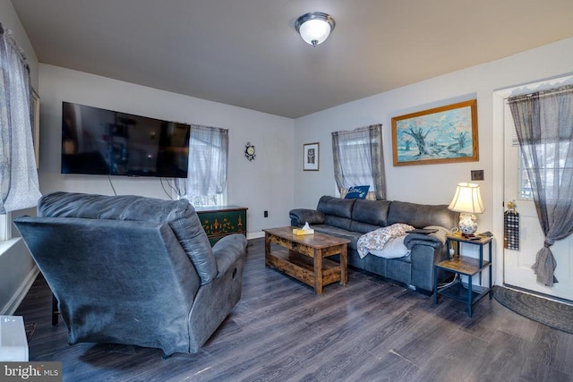 living room with a healthy amount of sunlight, baseboards, and dark wood-style flooring