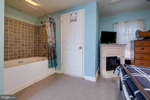 bedroom with baseboards and a glass covered fireplace