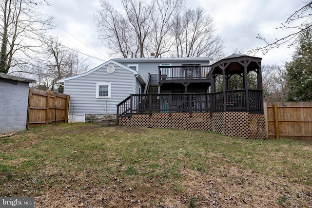 rear view of property featuring a gazebo, a yard, a deck, and fence