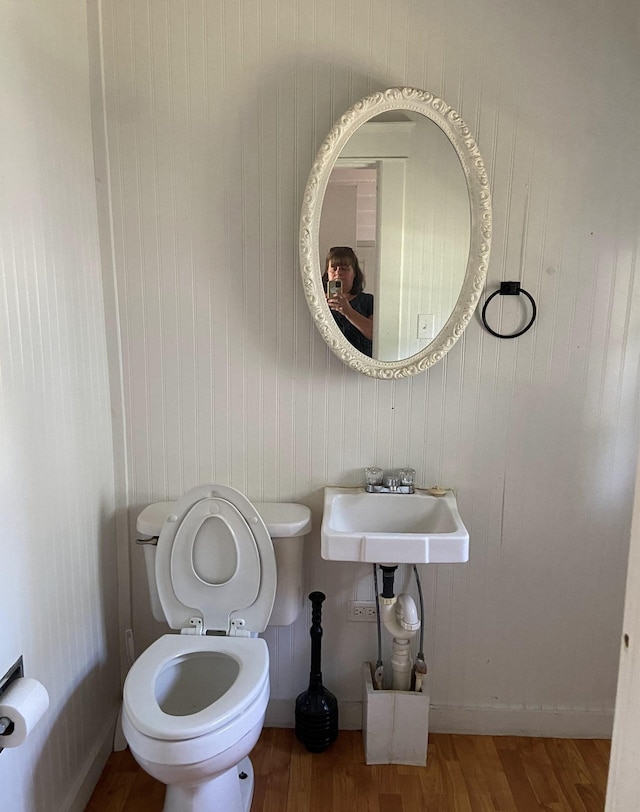 bathroom with hardwood / wood-style flooring, toilet, and sink