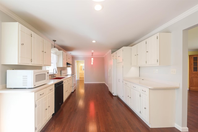 kitchen featuring dark wood-style floors, crown molding, white cabinets, a sink, and white appliances