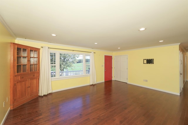 empty room featuring baseboards, ornamental molding, dark wood finished floors, and recessed lighting