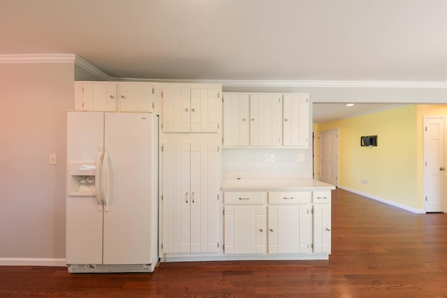 kitchen with crown molding, white refrigerator with ice dispenser, white cabinets, and baseboards