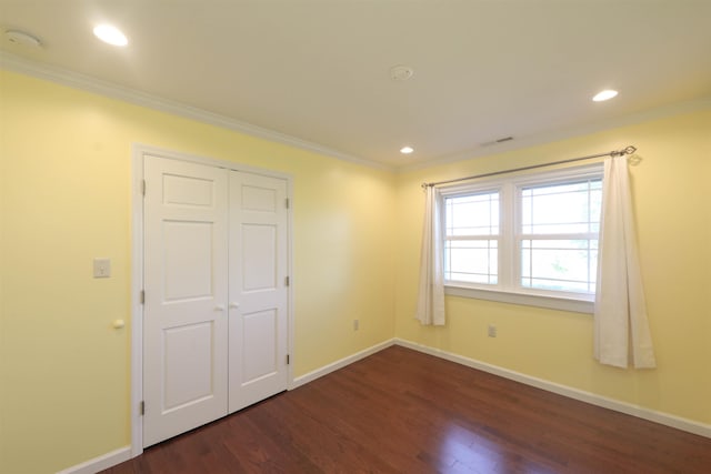 unfurnished bedroom with ornamental molding, dark wood-style flooring, and baseboards