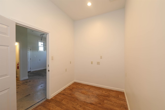 spare room with baseboards and wood finished floors