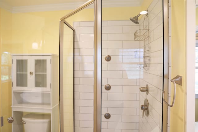 bathroom featuring a shower stall, toilet, and crown molding