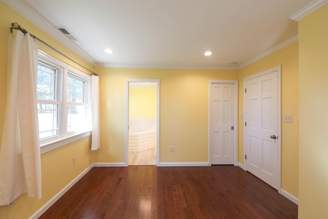 empty room with visible vents, baseboards, dark wood finished floors, and crown molding