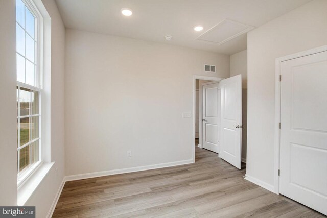 unfurnished room featuring a wealth of natural light and light hardwood / wood-style floors